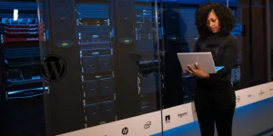 Woman holding a laptop as she works on web hosting servers