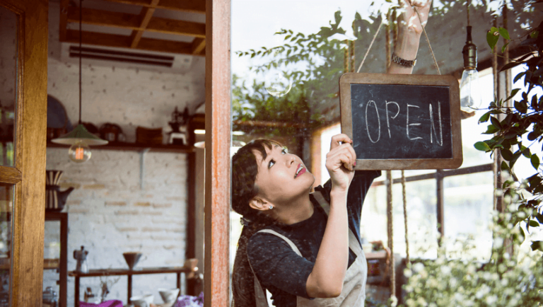 Business owner hanging an Open sign